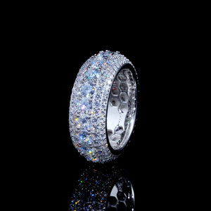 Angled profile close‑up shot of layered pave full iced‑out men’s eternity band ring sitting on glossy black reflective surface, mirror sparkle reflection below ring, hand‑set VVS1 D‑color hearts and arrows round moissanite stones, heavy‑weight 9mm wide S925 sterling silver white gold plated hip‑hop bling ring, visible hollow honeycomb inner band structure, brilliant rainbow fire and strong light refraction, premium men statement jewelry for streetwear and hip‑hop fashion, RDRIP JEWELRY
