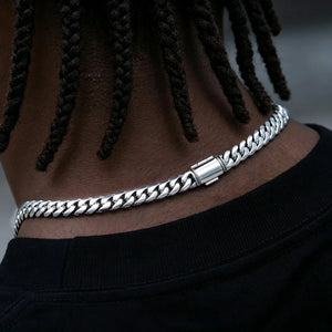 Back of neck closeup photo of black man with neat dreadlocks wearing 8mm Flagship Miami Cuban Link Chain in White Gold Tone, polished stainless steel curb necklace with smooth blank safety box clasp without engraved logo, tight interlock thick cuban links, anti-tarnish scratch resistant hip hop street jewelry for men, multiple lengths 16 18 20 22 24 inch shiny icy finish stackable everyday layering chain, durable heavy weight fashion accessory complete gift set with dust pouch and lifetime warranty RDRIP 