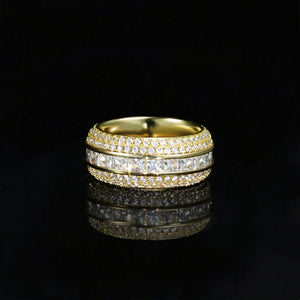 Front view shot of gold baguette princess cut triple band spinner eternity ring for men, hand set aaa cubic zirconia with micro pave surrounding stones, wide iced out hip hop band ring displayed on glossy black reflective surface, premium bling mens fashion jewelry RDRIP JEWELRY SINCE 2016
