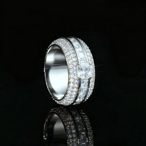Side profile view of silver tone baguette princess cut triple band spinner eternity ring for men, hand set aaa cubic zirconia micro pave stones, shiny iced out wide hip hop statement band ring displayed on black glossy reflective background, luxury mens bling jewelry RDRIP JEWELRY SINCE 2016
