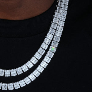 Side profile closeup shot of double layered stacked 8MM rectangular baguette cut VVS1+ D color moissanite tennis link chain worn on male model neck with plain black crew neck top, solid S925 sterling silver polished white gold finish, square cluster links with center baguette moissanite surrounded by round accent moissanite stones, bright rainbow fire and high light refraction, 9.25 Mohs hardness premium genuine moissanite not cubic zirconia or cheap diamond simulants, every hand prong set stone passes hand