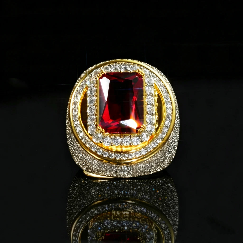 Front halo close‑up studio shot of two‑tone 18k gold plated men hip‑hop champion ring, eye‑catching large radiant‑cut red ruby center gemstone, double layered halo setting with hand‑set micro pave cubic zirconia stones, heavy thick wide band, brilliant icy bling sparkle, resting on glossy black reflective mirror surface, deep dark background, premium bold rapper statement fashion jewelry RDRIP JEWELRY
