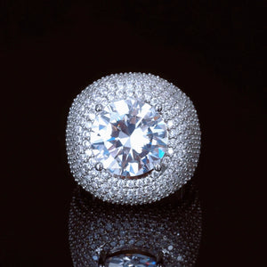Front top‑down view of men's hip‑hop Glory Dome Iced Clustered Band Ring, huge round brilliant cut center stone secured by four prongs, full layered micro pave hand‑set VVS flawless simulated diamonds dome band, heavy 18K white gold plated bling statement mens ring, shot on dark black reflective background RDRIP JEWELRY

