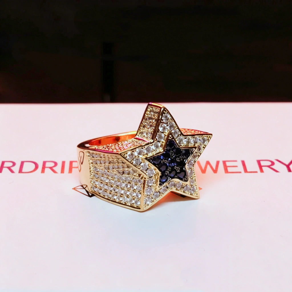 Side view shot of men's gold‑toned iced out double pentagram star hip hop ring, fully micro‑paved wide band covered with AAA white cubic zirconia stones, center inlaid deep blue CZ star, heavy‑weight statement rap jewelry for street style, premium hand‑set bling ring for men gift collection from RDRIP JEWELRY
