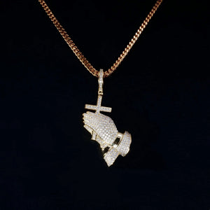 Close‑up studio shot of gold iced out praying hands pendant with cross charm paired with gold cuban link chain, 18k gold plated fully set flawless vvs simulated diamonds, hip hop religious bling mens necklace against solid black background RDRIP JEWELRY

