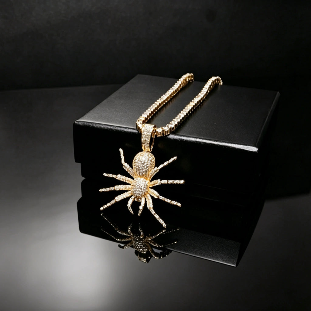 Gold plated Iced Tarantula Spider Pendant with baguette tennis chain laid on premium black gift box, full micro pave VVS simulated diamonds hip hop necklace for men, product shot on seamless black glossy reflective surface, luxury bling rap streetwear jewelry RDRIP JEWELRY
