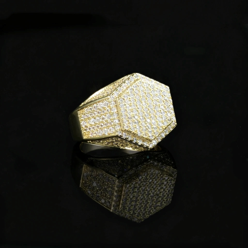 Gold plated men hip hop hexagon signet ring full micro‑inlay pave set sparkling cubic zirconia stones icy bling geometric hexagonal rapper statement ring polished gold metal angled product photograph with clear mirror reflection on glossy black surface RDRIP JEWELRY
