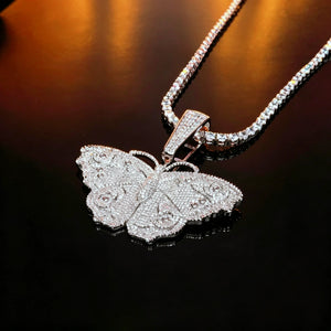 Iced Out Large Vintage Butterfly Pendant close‑up shot laid on black reflective surface, full micro pave AAA cubic zirconia hip hop bling necklace with matching tennis chain, 18k gold plated copper vintage street style jewelry for men women RDRIP JEWELRY SINCE 2016
