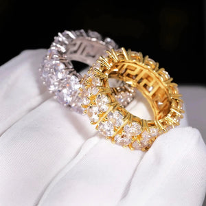 Iced micro pave double row band ring gold and silver tone held in white glove, hand‑set prong‑lifted cubic zirconia hip hop eternity ring for men women, shiny full bling icy plated statement jewelry for party street style RDRIP JEWELRY
