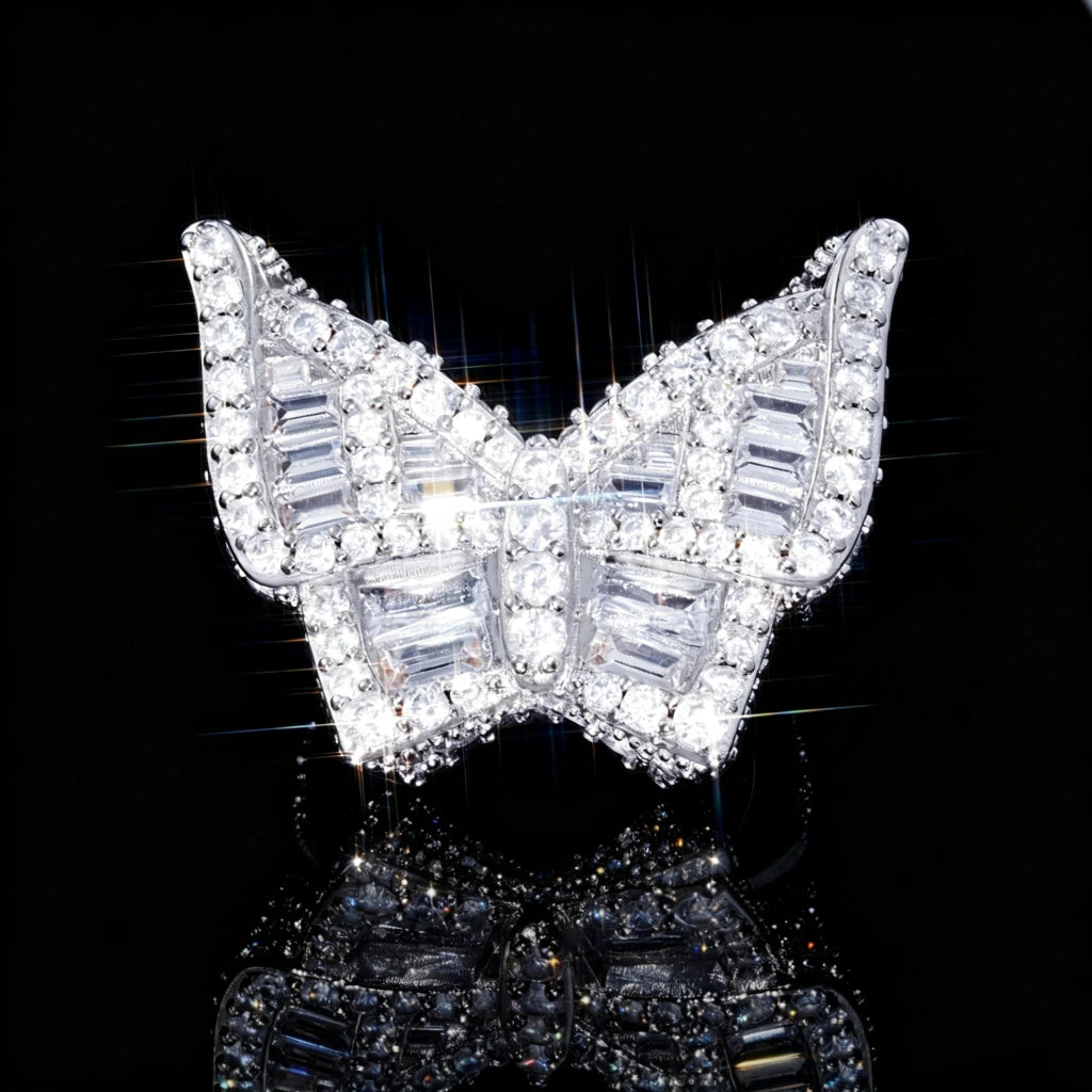 Silver finish iced out baguette butterfly ring front close‑up shot, heavy 3D hip hop men statement ring, fully hand‑set baguette cut and round cubic zirconia rhinestone stones, bright dazzling bling diamond‑simulated hip‑hop jewelry, star‑burst sparkle light effect on black reflective studio background RDRIP JEWELRY
