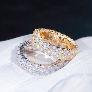 RDRIP JEWELRY iced out double row eternity band gold silver rings overlap stacked display placed on soft white cotton glove prong‑set 3mm round VVS simulated diamonds full iced hip hop mens stackable ring 6mm width copper base bling jewelry detailed studio close‑up view dark blurred background
