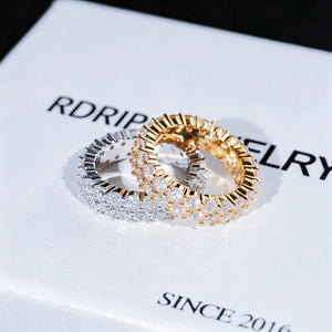 RDRIP JEWELRY iced out double row eternity band gold silver rings stacked overlapping on white branded gift box marked SINCE 2016 prong‑set 3mm round VVS simulated diamonds full iced hip hop mens stackable ring 6mm width copper base bling jewelry studio close‑up product shot dark blurred background
