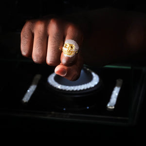 Black male hand wearing two tone 3D iced out skull ring, micro pave cubic zirconia hip hop bling ring for men, 18k gold plated heavy statement jewelry, dark studio lifestyle shot RDRIP JEWELRY
