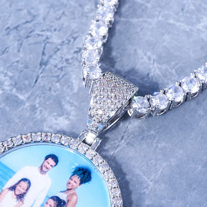 Classic Iced Out Circle Custom Photo Pendant Necklace close-up detail shot, silver fully paved stone bail and single row halo frame with tennis chain, placed on grey marble surface, personalized custom photo hip hop jewelry, RDRIP JEWELRY
