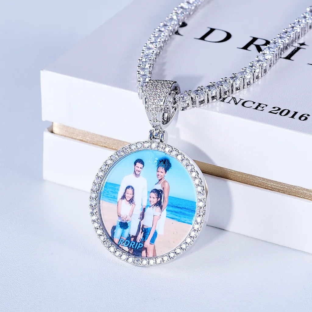 Classic Iced Out Circle Custom Photo Pendant Necklace, silver tone circular family photo medallion with single row stone frame, matched tennis chain, displayed on branded RDRIP white gift box printed with SINCE 2016, studio commercial shot, personalized hip hop memory jewelry, RDRIP JEWELRY
