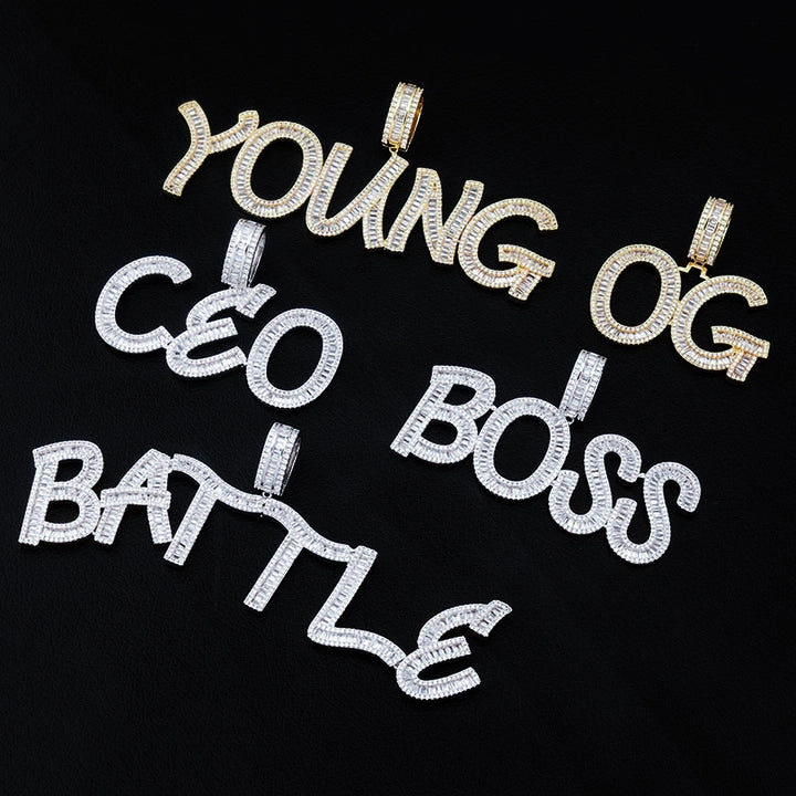 Iced Out Baguette Custom Name Letter Pendant Necklace, flat lay collection shot, gold tone & white gold tone letter pendants including YOUNG, OG, CEO, BOSS, BATTLE, mixed baguette cut stones, solid black background, customizable hip hop personalized name jewelry, RDRIP JEWELRY
