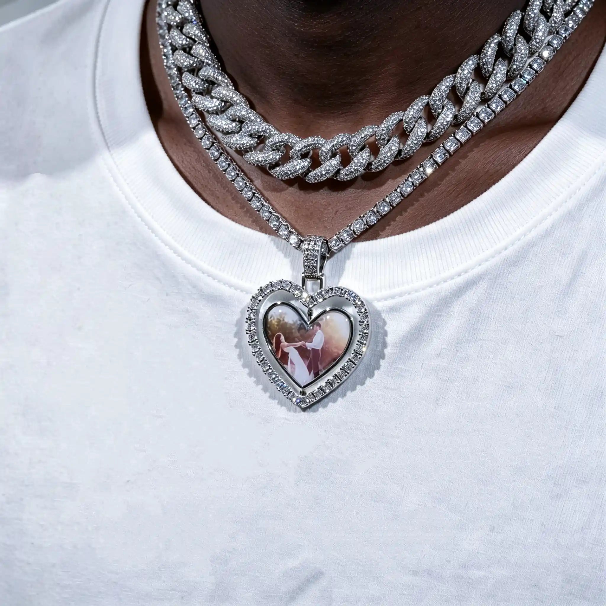 Iced Out Double Sided Rotatable Heart Custom Photo Pendant, silver tone layered with iced cuban link chain, worn on dark black skin model in plain white t-shirt, couple portrait inside heart locket frame, hip hop personalized custom photo necklace, RDRIP JEWELRY
