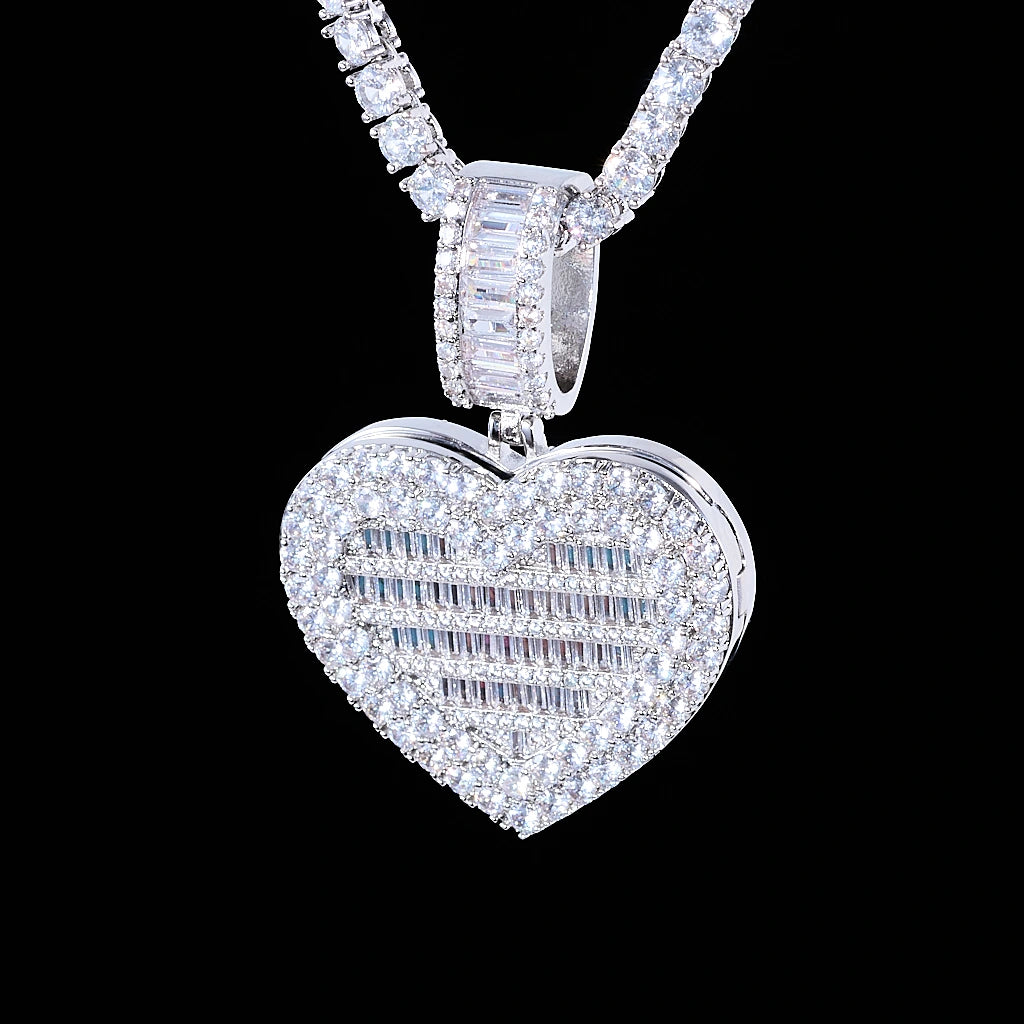 Iced Out Heart Locket Custom Photo Pendant Necklace, white gold tone closed hanging front view, fully iced heart locket with mixed round and baguette cut stones, baguette stone encrusted bail, paired tennis chain against solid black background, openable personalized hip hop custom photo jewelry, RDRIP JEWELRY
