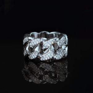 Front view of iced out silver tone miami cuban link men ring, thick wide hollow band with micro pave cubic zirconia stones, luxury hip hop bling statement ring displayed on black reflective surface with mirror reflection by RDRIP JEWELRY
