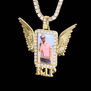 Iced Out Wings RIP Custom Photo Pendant, gold tone hanging front view, angel wing rectangular custom photo frame pendant with RIP letter decoration, encrusted round stones, matched tennis chain, solid black background, memorial personalized hip hop keepsake jewelry, RDRIP JEWELRY
