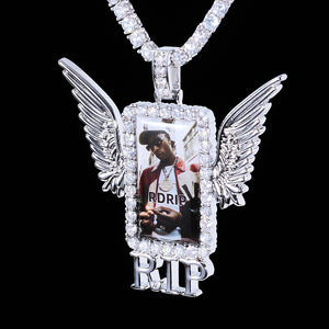 Iced Out Wings RIP Custom Photo Pendant, white gold tone hanging front view, angel wing rectangular custom photo frame pendant with RIP letter decoration, encrusted round stones, matched tennis chain, solid black background, memorial personalized hip hop keepsake jewelry, RDRIP JEWELRY
