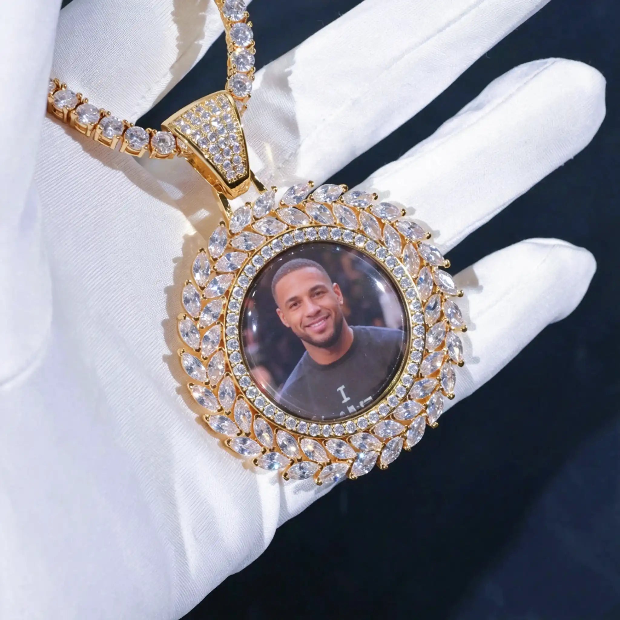 LARGE 3D DELUXE WHEAT EAR CUSTOM PICTURE PENDANT, gold plated iced out multi-layer marquise wheat ear border custom memory photo charm, upgraded sunflower style portrait medallion hip hop jewelry matched with tennis chain, product shot holding pendant with white cotton glove, dark studio background, crystal clear shiny stones, RDRIP JEWELRY
