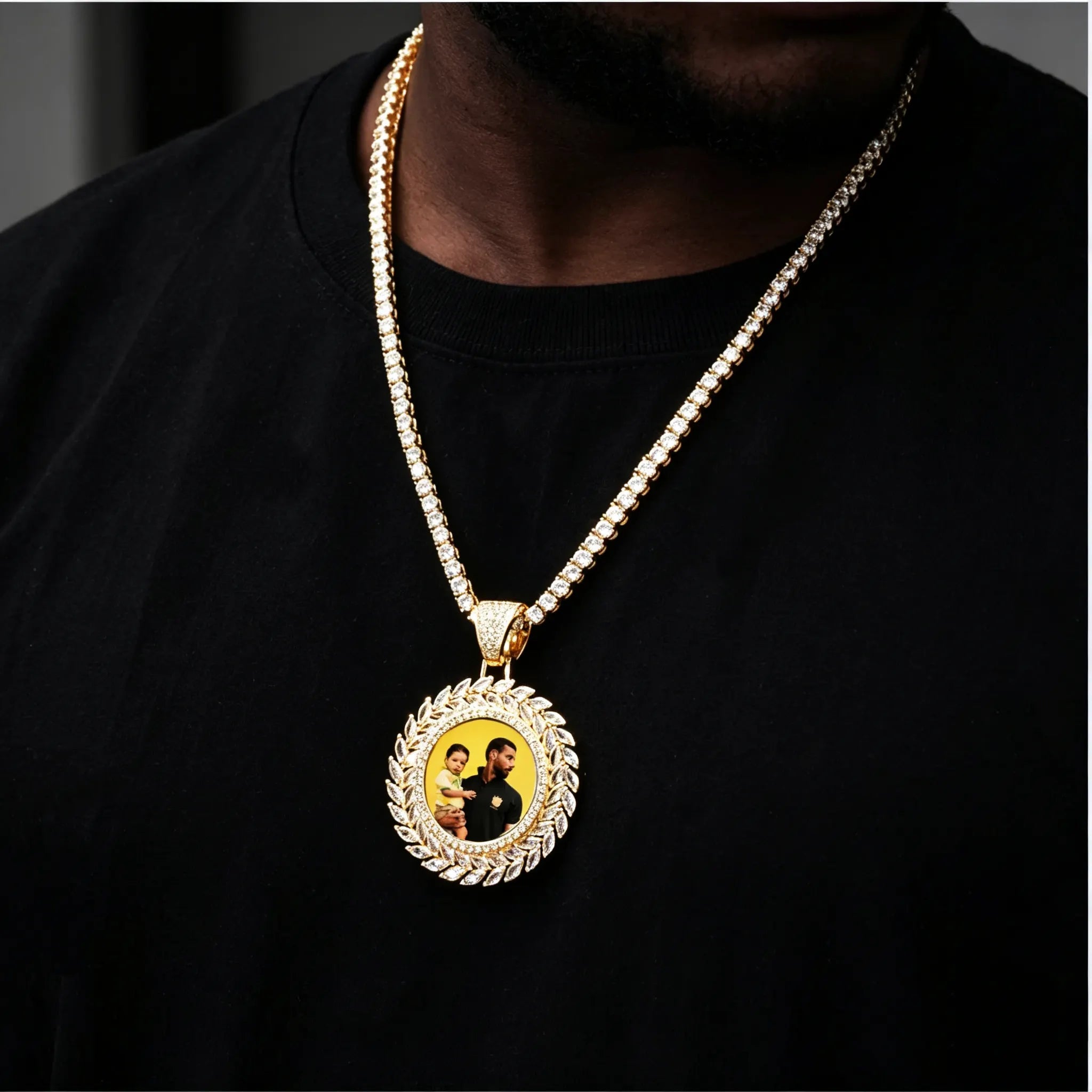 LARGE 3D DELUXE WHEAT EAR CUSTOM PICTURE PENDANT, gold plated iced out multi-layer marquise wheat ear border custom memory photo charm, upgraded sunflower style portrait medallion hip hop jewelry matched with tennis chain, lifestyle wearing shot on male model, dark black shirt, soft blurred grey background, RDRIP JEWELRY
