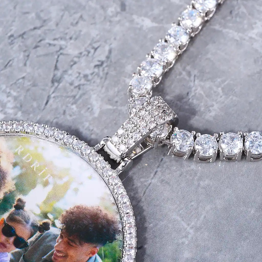 Close-up of Medium 3D Circle Custom Picture Pendant, custom photo medallion with bling stone frame, personalized family memory necklace, iced out bail and tennis chain hip hop pendant for men, grey marble surface, RDRIP JEWELRY

