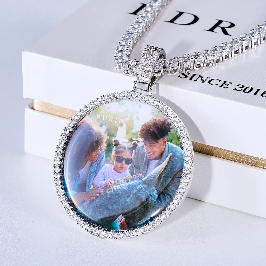 Medium 3D Circle Custom Picture Pendant, custom memory family photo round medallion, iced out border hip hop pendant necklace with tennis chain placed on branded gift box, lifestyle product shot on white tabletop, RDRIP JEWELRY
