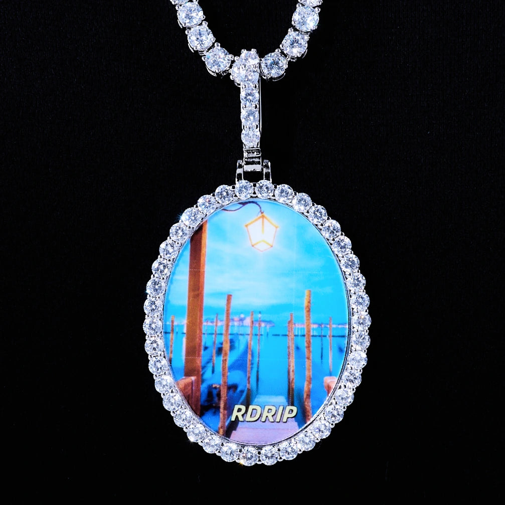 Oval Halo Custom Photo Pendant Necklace, silver tone iced oval picture medallion surrounded by round halo stones, paired with tennis chain, studio product shot on solid black background, RDRIP JEWELRY
