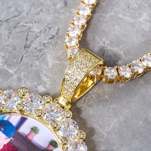 Round Big Stone Halo Custom Photo Pendant Necklace close-up view, gold fully iced out bail and large stone halo frame with tennis chain, placed on grey marble surface, custom photo hip hop jewelry, RDRIP JEWELRY

