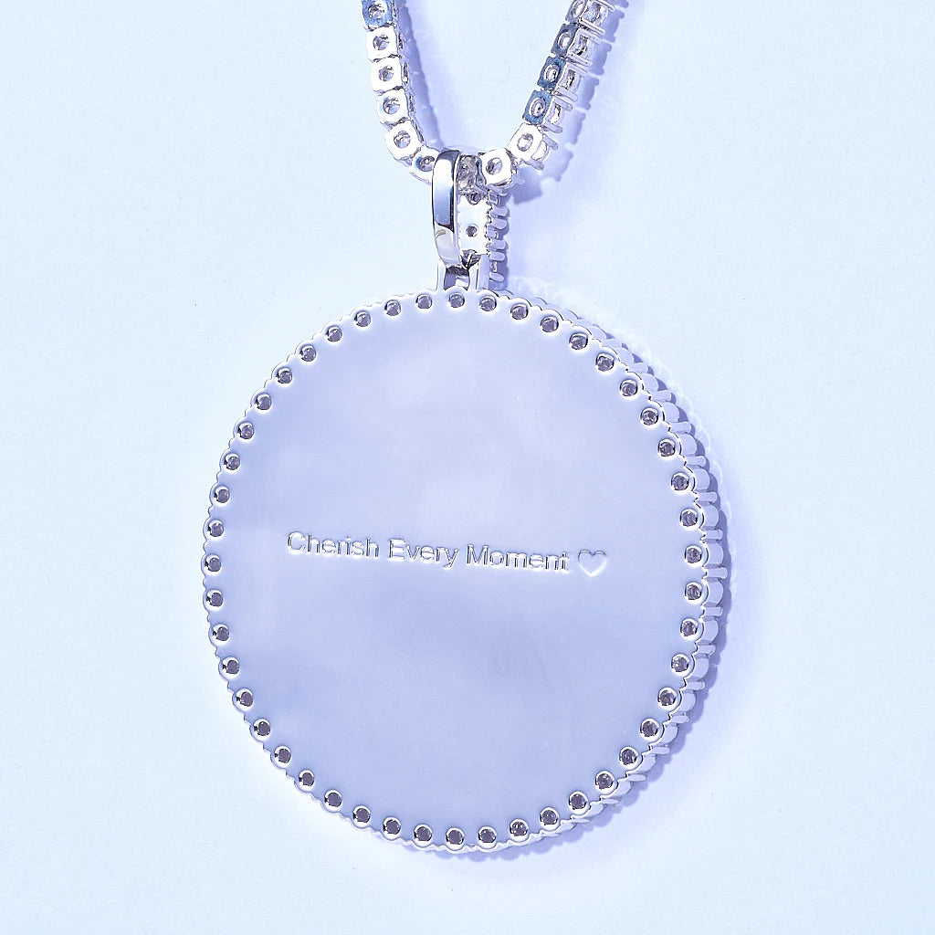 VVS MOISSANITE LARGE 3D CIRCLE CUSTOM PICTURE PENDANT, close-up detail of pendant reverse side with customizable engraved text "Cherish Every Moment", silver iced out photo medallion hip hop necklace with tennis chain on pale light blue background, RDRIP JEWELRY
