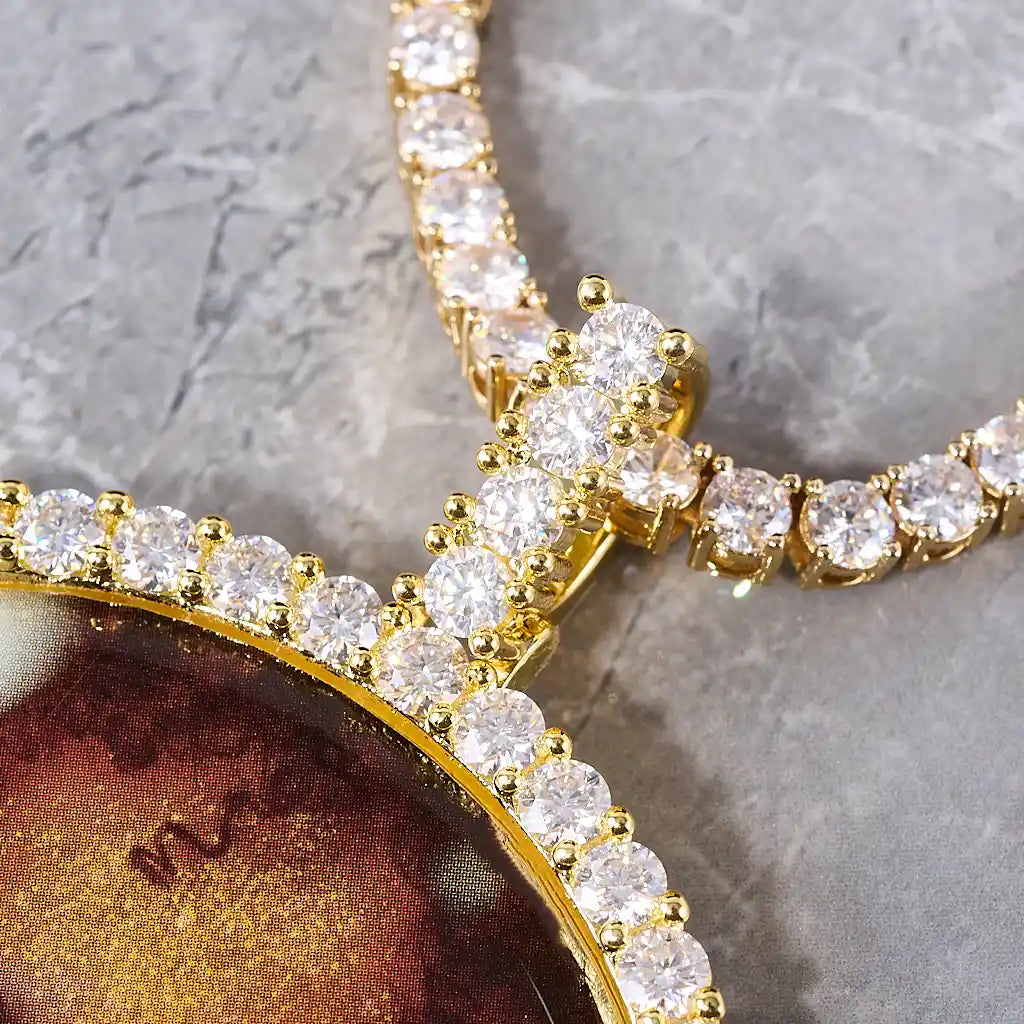 VVS MOISSANITE LARGE 3D CIRCLE CUSTOM PICTURE PENDANT, close up detail of gold tone stone encrusted bail and diamond frame, paired with matching tennis chain, grey marble texture background, RDRIP JEWELRY
