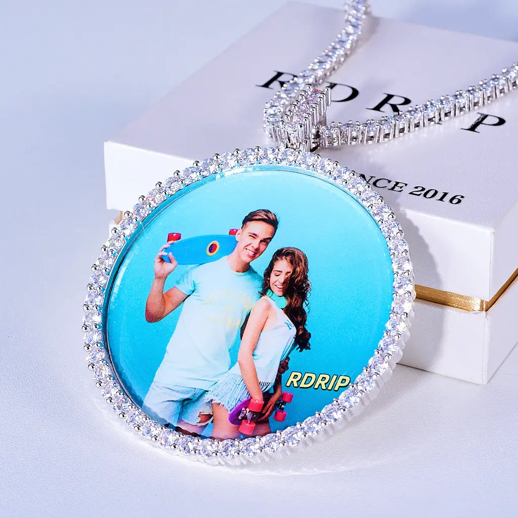 VVS MOISSANITE LARGE 3D CIRCLE CUSTOM PICTURE PENDANT, silver tone personalized couple photo medallion hip hop necklace with tennis chain, displayed on official RDRIP jewelry gift box, light white surface background, RDRIP JEWELRY
