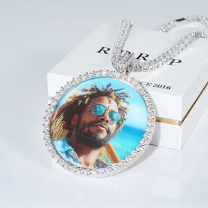 VVS MOISSANITE LARGE 3D CIRCLE CUSTOM PICTURE PENDANT, iced out round customized memory picture charm, personalized photo medallion hip hop jewelry with matching tennis chain, lifestyle shot arranged on branded white gift packaging box, light grey surface background, RDRIP JEWELRY
