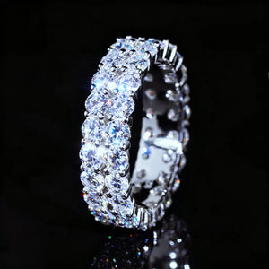 Side profile shot of 6 mm width double‑row full pave moissanite eternity ring, hand‑set D‑Color VVS1+ round hearts‑and‑arrows moissanite gemstones, polished 925 sterling silver white gold plated icy hip‑hop ring, bright rainbow fire and heavy sparkle against dark glossy black background, premium unisex bling statement jewelry for men and women RDRIP JEWELRY SINCE 2016
