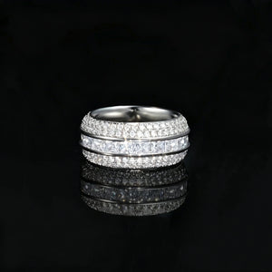 Front straight angle studio shot of silver tone baguette princess cut triple band spinner eternity ring for men, fully iced out with hand set aaa cubic zirconia micro pave stones, wide heavy hip hop statement band ring on glossy black reflective background, premium mens bling fashion jewelry RDRIP JEWELRY SINCE 2016
