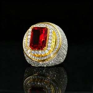 Three‑quarter angle studio product photo of two‑tone 18k gold plated men hip‑hop champion ring, large rectangular radiant‑cut red ruby center gem secured by gold prongs, striking double layered halo setting, full micro pave hand‑set cubic zirconia stones all over heavy thick wide band, brilliant icy bling and sparkling light effects, presented on glossy black mirror reflective surface, solid dark studio background, bold luxury rapper statement jewelry RDRIP JEWELRY

