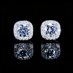 VVS1 Moissanite 7MM Cushion Halo Stud Earrings, 925 sterling silver white gold plated screw-back unisex hip hop studs, round center VVS1 moissanite stone with pave cushion halo frame, brilliant diamond-like fire, dazzling sparkle and bright starburst highlights, close-up product shot with clear mirror reflection on glossy black background, RDRIP JEWELRY
