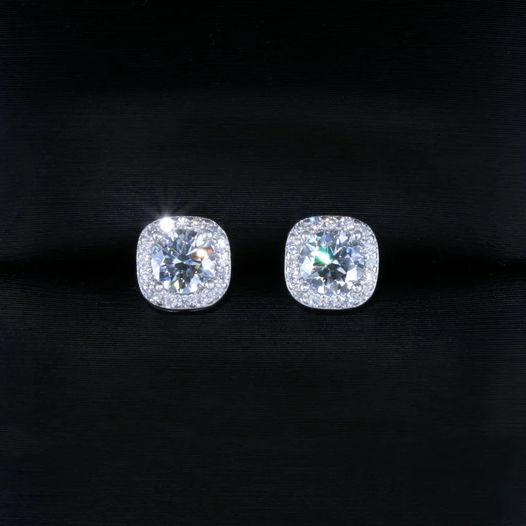 VVS1 Moissanite 7MM Cushion Halo Stud Earrings, 925 sterling silver white gold plated screw‑back earrings for men, round center moissanite stone with pave cushion halo frame, brilliant fire and sparkle, unisex iced‑out hip hop bling studs photographed on dark silk fabric background, RDRIP JEWELRY
