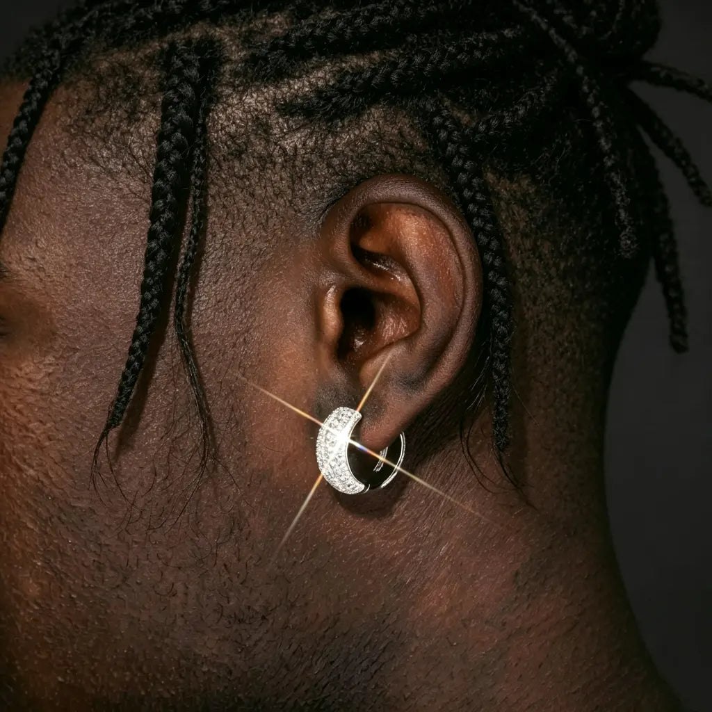 VVS1 Moissanite Full Iced Wide Pavé Huggie Hoop Earrings lifestyle close‑up on male model with loose casual dreadlocks, 925 sterling silver white gold plated click‑lock huggie hoop, full pave moissanite stones with bright starburst sparkle, real ear wear presentation, hip‑hop men’s bling jewelry, RDRIP JEWELRY
