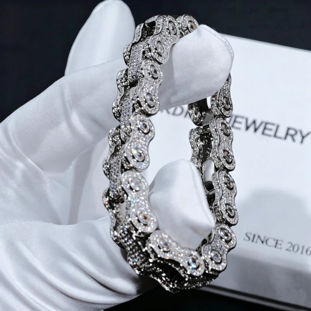 White gold plated 11mm full iced out bike chain link bracelet for men hip hop street jewelry, fully paved flawless VVS simulated diamond motorcycle link wrist chain with hand set no glue stones, close-up shot held by white soft cotton glove against white brand box printed RDRIP JEWELRY SINCE 2016, ultra bling all-angle shine heavy drip biker bracelet available in 7 inch 8 inch sizes premium men statement accessory gift RDRIP JEWELRY
